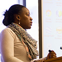 black woman speaking to gathering.