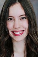 Young woman with ivory skin smiling, long black/brown hair 