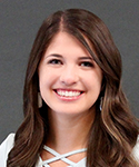 smiling woman with dark brown hair and white criss cross top