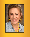 young woman with light brown hair pulled back; yellow jewelry