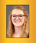 young woman with golden brown long wavy hair, large frame glasses