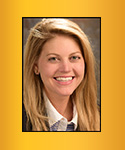 woman with honey-blonded, below shoulder-length hair, white collared shirt