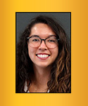 Young smiling woman with long dark brown full hair and large frame glasses