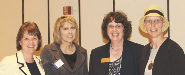 four business women posing fo a picture