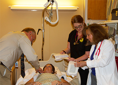 Doctor, nurse manager and student tend to patient