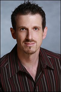 man with spiked hair, moustache and slight goatee, striped shirt