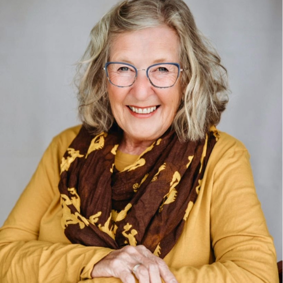 photo of suzey delger in yellow shirt with uw cowboys scarf
