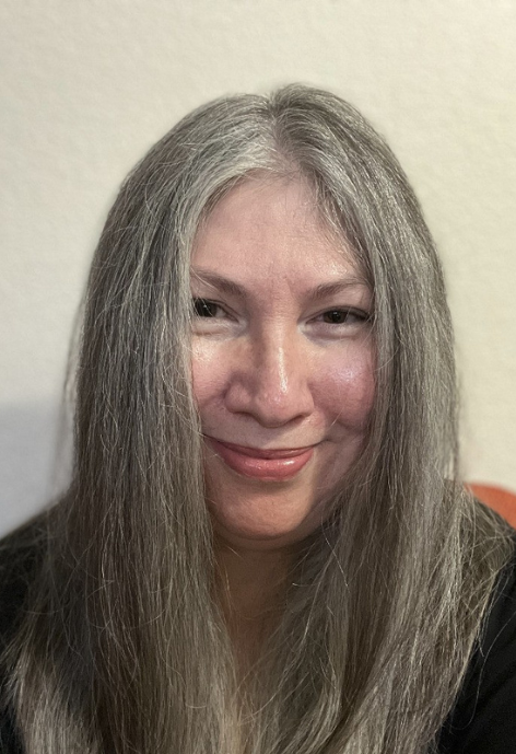 fran nunez in a black blouse in front of a white backdrop