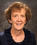 woman with short brown hair and deep blue ruffled collar poses for portrait picture