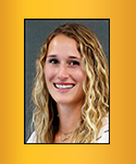 Young smiiling woman with long brown curly/wavy hair and blonde highlights