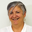 woman in a white blouse with greying hear and a big smile