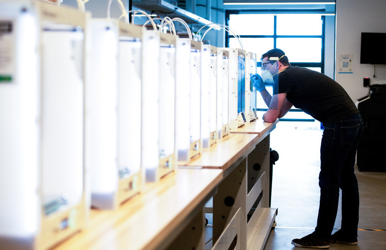 a student looks at their project in a 3d printer