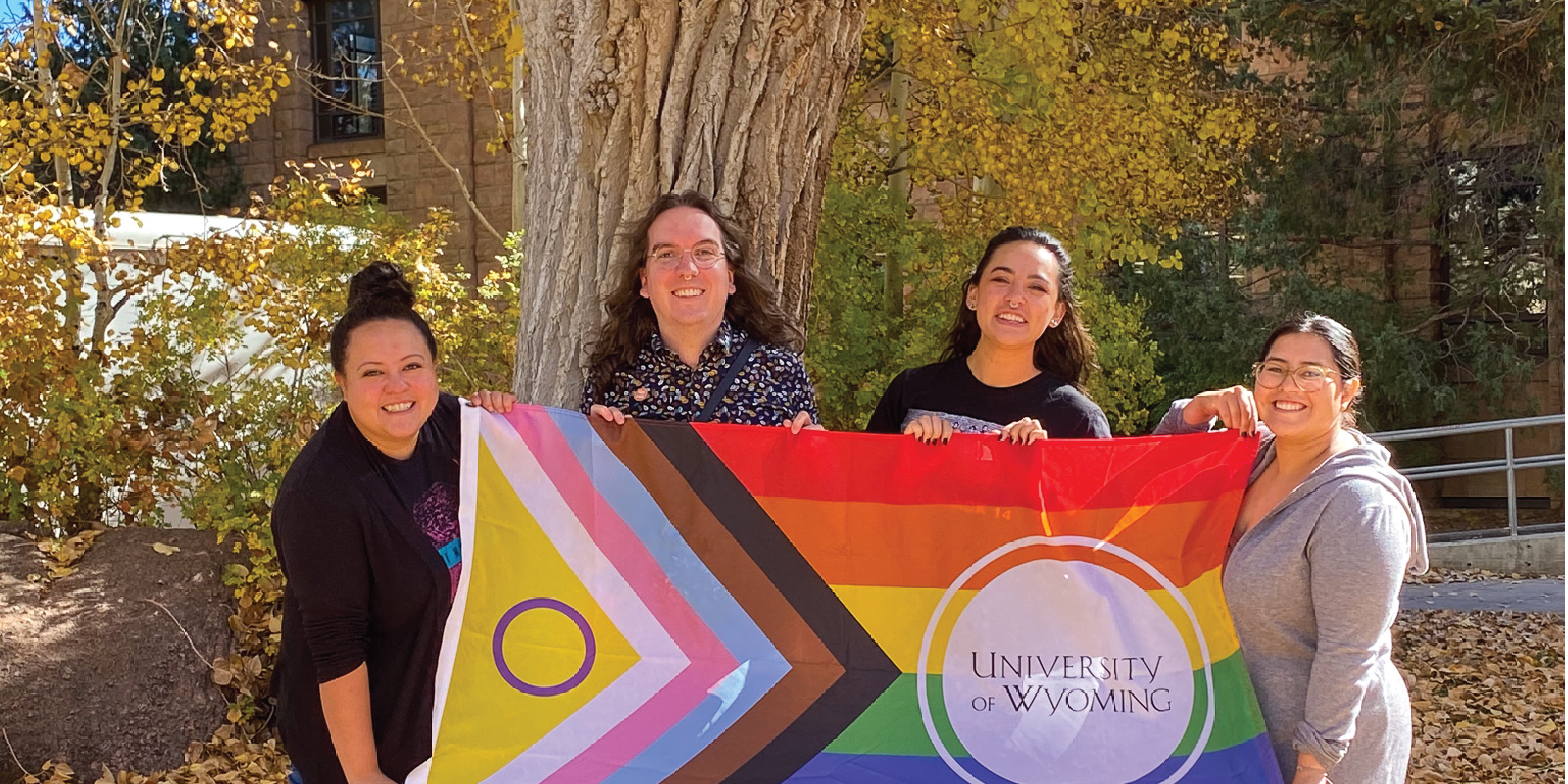 MA staff outside of the Wyoming Union with a progressive pride flag