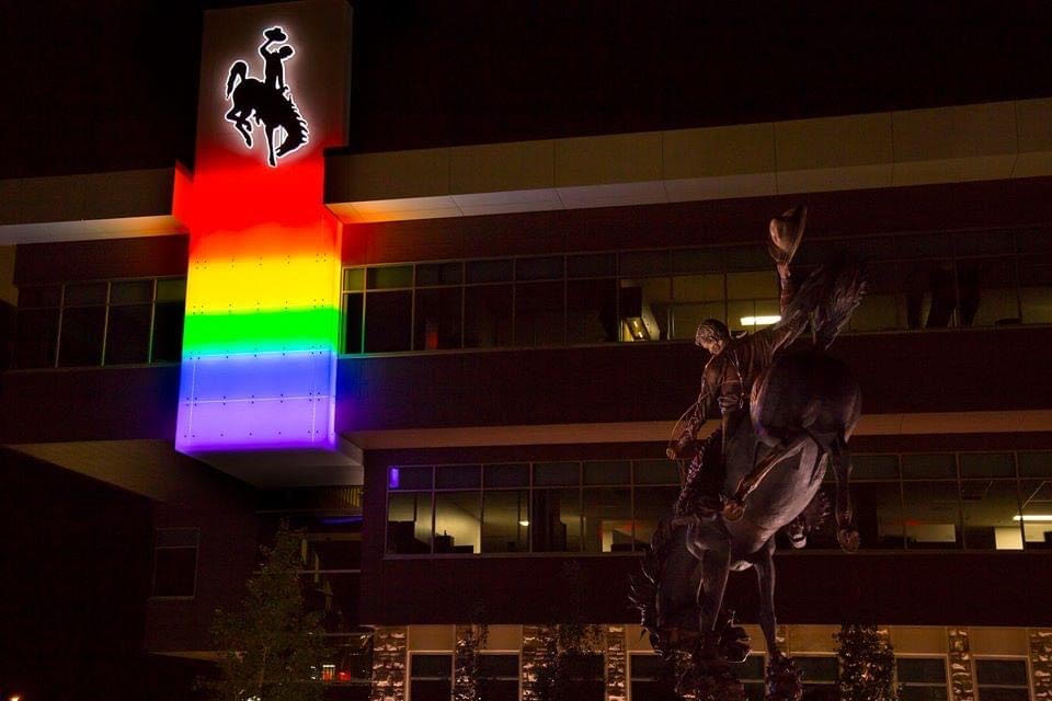 The UW Gateway Center building at night with an illuminated pride sign outside.