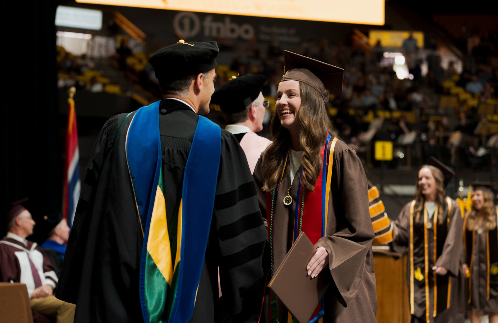 A UW graduate shakes hands with a professor as they receive their degree.