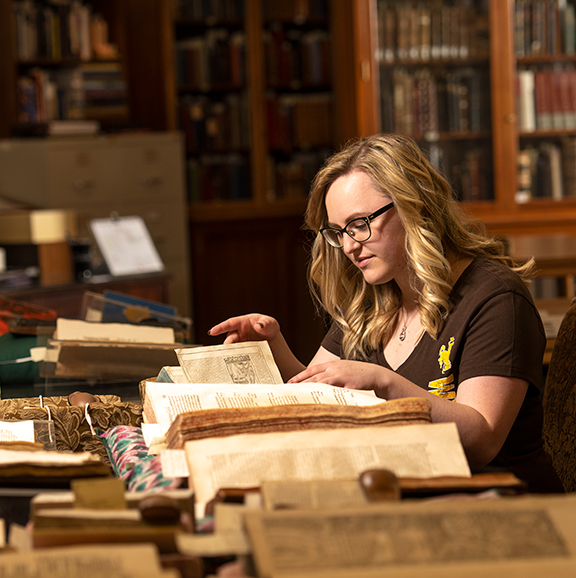 Student looking through books.