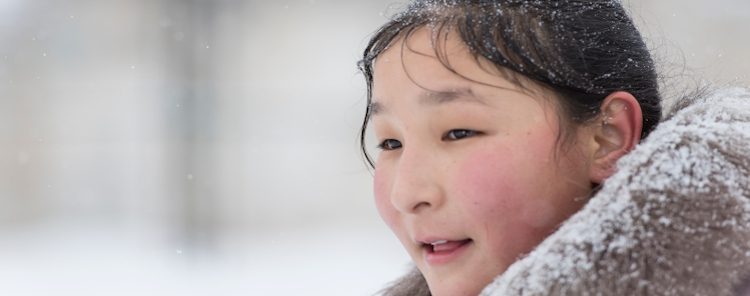 A young girl in standing in the snow in the Kyrgyz Republic