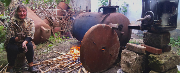 A woman sitting in her back yard in Moldova making Raciu