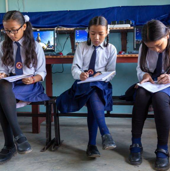 3 girls doing school work in Nepal