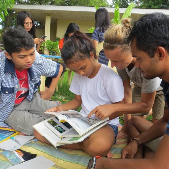students discussing a book in the Philippines