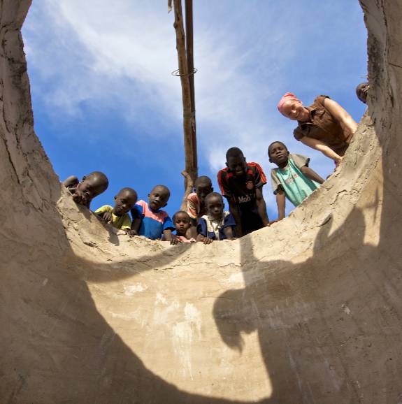 pcv volunteer and children looking at a water infrastructure project in Senegal