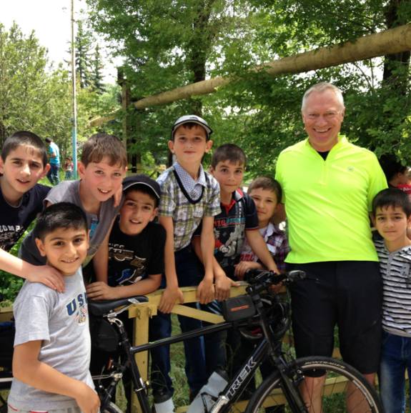 kids and a pcv in Armenia standing around a bike
