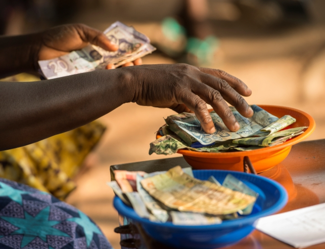 A small business stall in Ghana with money bowls
