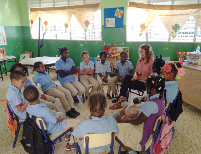 Children and a teacher sitting in a circle in a classroom in the dominican republic