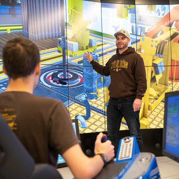 Senior Academic Professional Lecturer Tawfik Elshehabi (purple shirt and tie), oversees the Drilling and Completions Simulation Laboratory.  The state-of-the-art lab is not only for petroleum engineering students but also mechanical, electrical and computer engineering students...Nicholas Shields (short-sleeves), mechanical engineering student, Littleton, CO;..Benjamin Jellicoe (long-sleeves, cap), petroleum engineering student, Saskatoon Canada