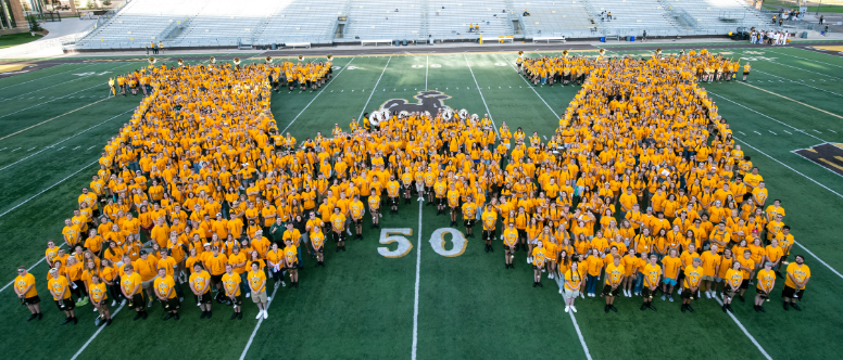 Gold 'W' made of students on football field