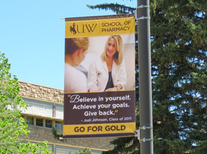 University of Wyoming School of Pharmacy alumna Jodi Johnson (Pharm.D. ’11) and Pharm.D. Candidate Forrest Floyd (class of 2015) are featured on banners in the UW Go for Gold Campaign. 