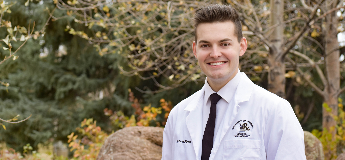 male pharmacy student in white coat