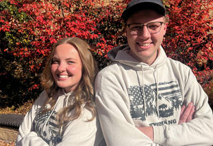 students in front of red leaves
