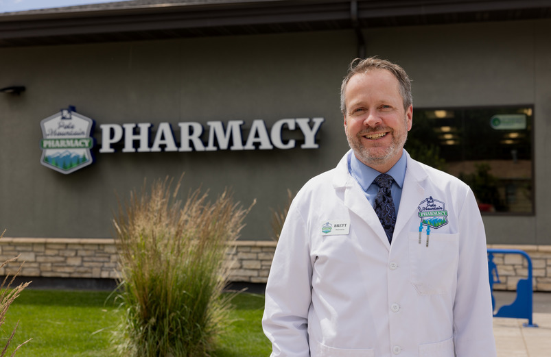 pharmacist in front of his business