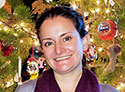 Woman smiling in front of  Christmas tree