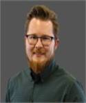 Colton Johnson, PharmD Smiling man with glasses and a green shirt