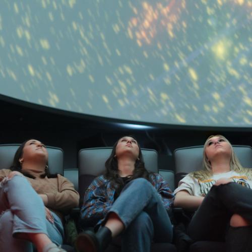 students watch a planetarium show