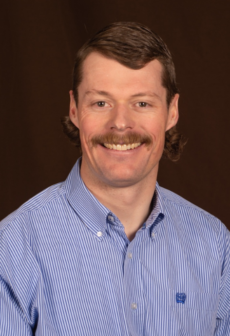 Smiling man with mustache and striped shirt