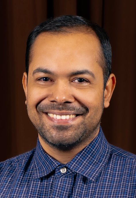 Smiling man wearing a blue plaid shirt