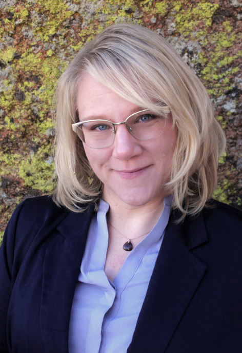 Smiling woman outside wearing purple blouse and black blazer