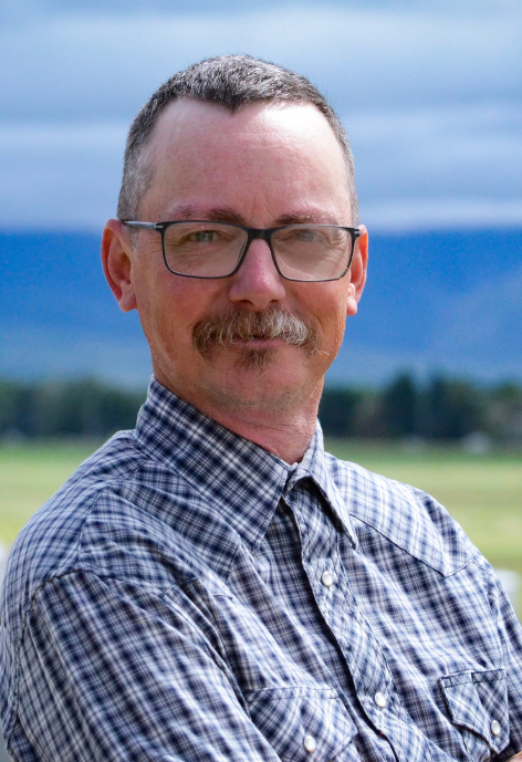Smiling man with glasses and plaid shirt