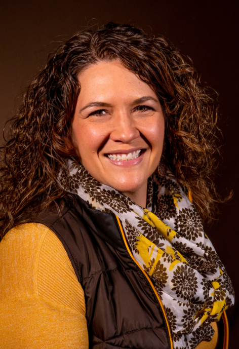 Smiling woman wearing UW brown and gold clothes