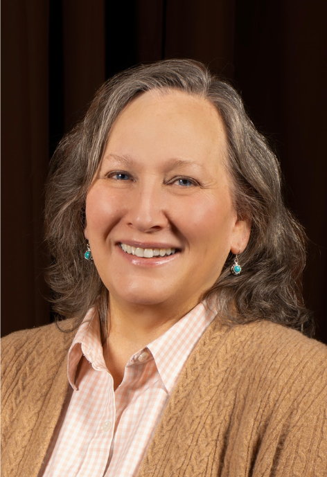 Smiling woman wearing tan sweater and checked blouse