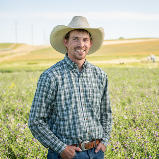 A student smiles out in a field