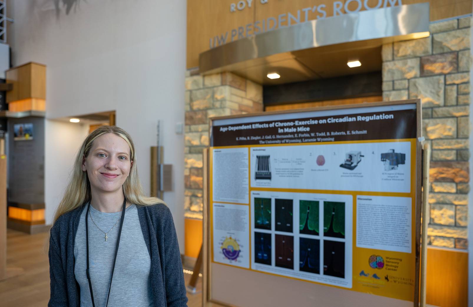 A woman standing next to a research poster.