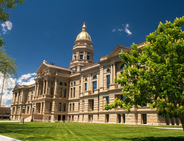The Wyoming State capitol building shown against a vibrant blue sky.