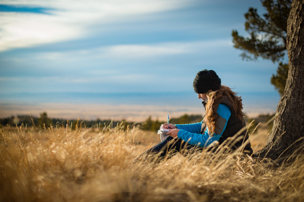 student sitting under a tree