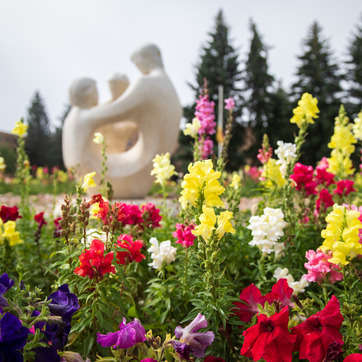 Statue on campus with flowers