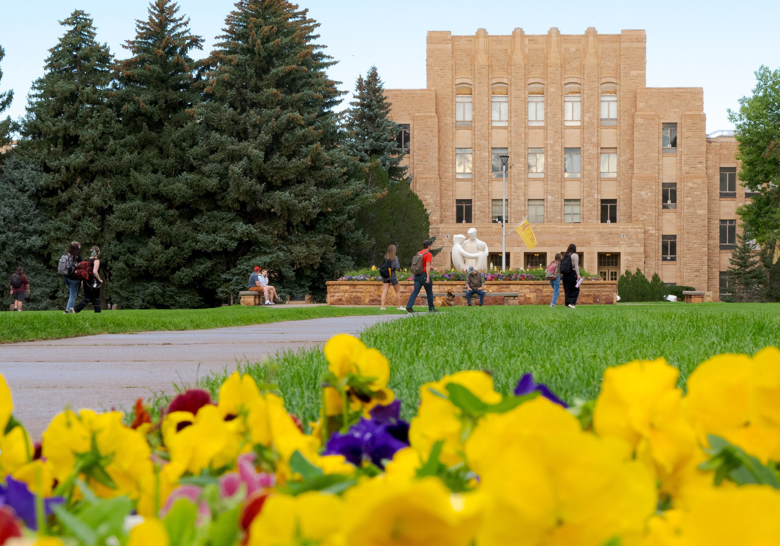 View of Arts & Science from Prexy's Pasture with flowers in the foreground.