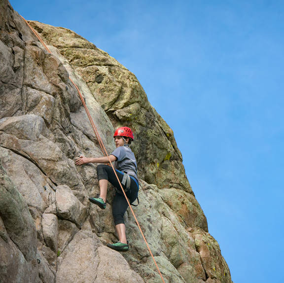 A student climbs a rock at Vedauwoo